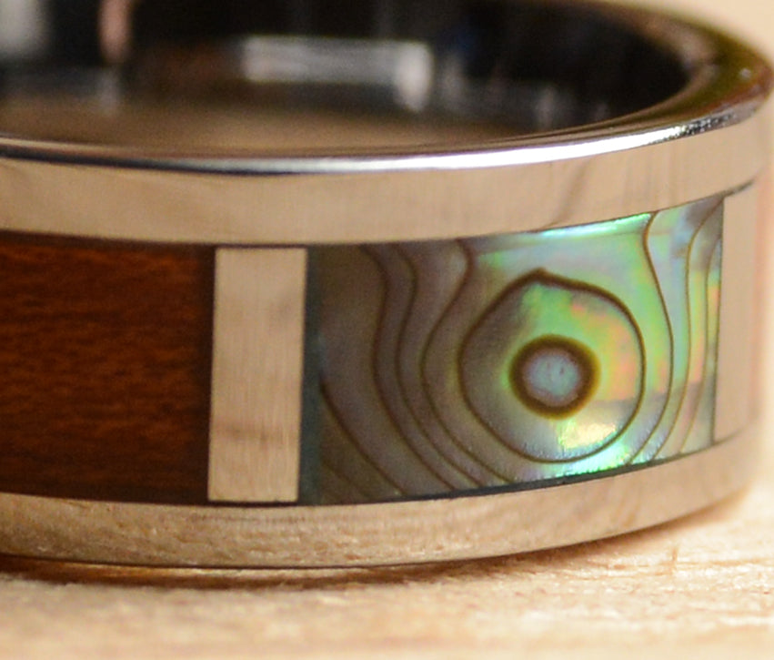 Close view of abalone shell koa and tungsten wood wedding band from Urban Designer.