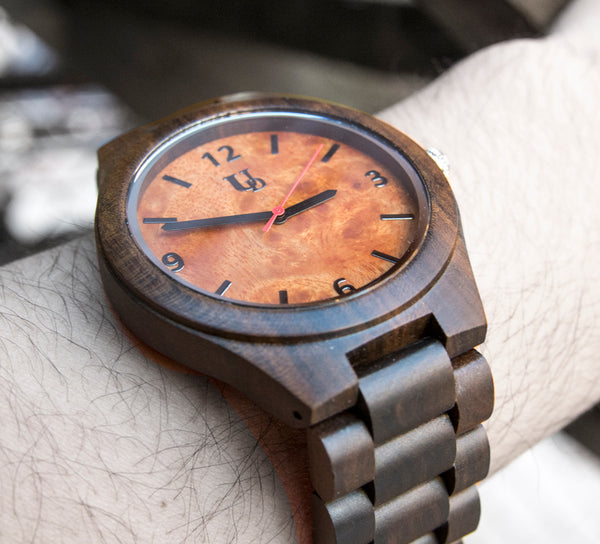A natural wood watch made of sandalwood with an orange face and a red second hand from Urban Designer.